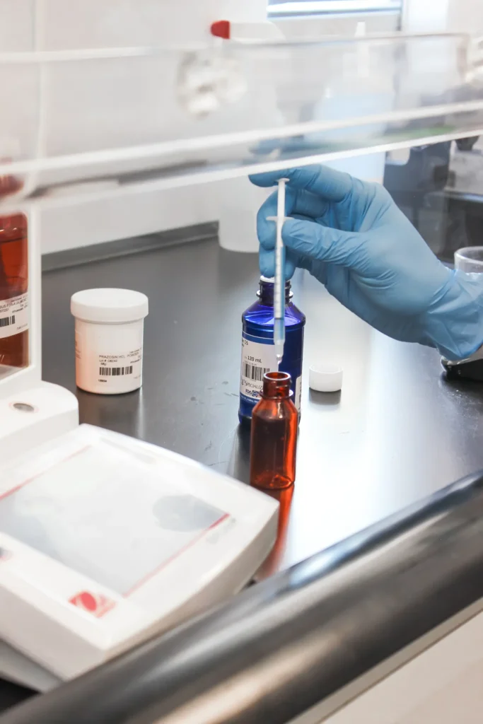 Pharmacist Using a Pipette at a Compounding Workstation